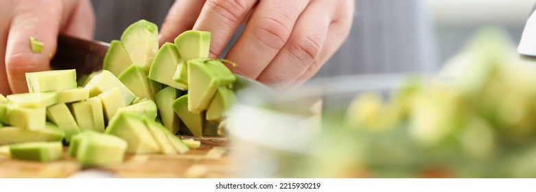 Man cutting mellow avocado on cutting board, inspiration to cook tasty dinner - Shutterstock ID 2215930219