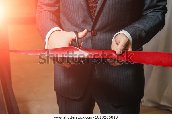 A man cutting a red ribbon, opening ceremony,\
isolated on white background