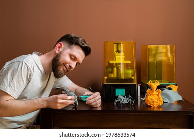 Man cutting rests of 3d printer figurine with cutters 
