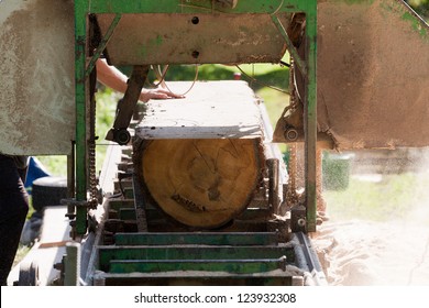 A Man Cutting Timber On A Portable Sawmill.