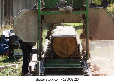 A Man Cutting Timber On A Portable Sawmill.