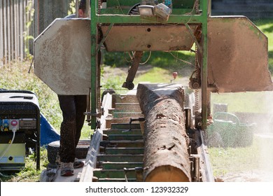 A Man Cutting Timber On A Portable Sawmill.