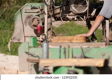 A Man Cutting Timber On A Portable Sawmill