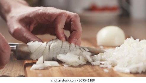 man cutting white onion with knife