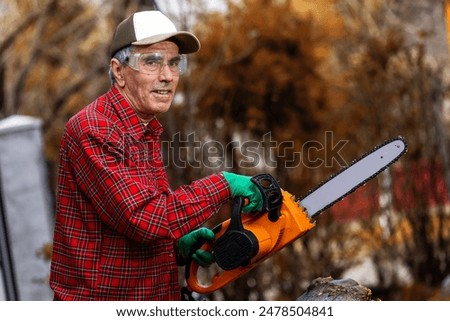 Man cutting wood with saw, dust and movements. Chainsaw.