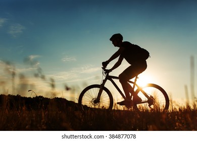 Man Cyclist with bike on sunset