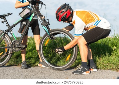 Man cyclist repairing a bike against the background of sky 
 - Powered by Shutterstock