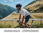 Man cyclist is training a bicycle. Sports motivation image.Good road for cycling. Man cyclist riding a gravel bike with a view of the mountains. Travel biking concept. Transfăgărășan road in Romania.