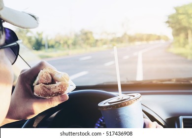 Man Is Dangerously Eating Hot Dog And Cold Drink While Driving A Car