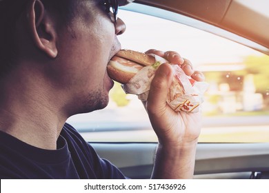 Man Is Dangerously Eating Hot Dog And Cold Drink While Driving A Car