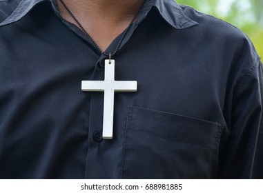 Man Dangling A Cross Necklace