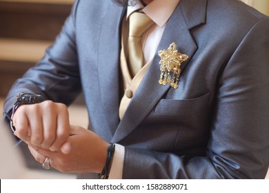 Man In Dark Grey Suit Two Bottons Golden Star Brooch, Checking Whatch, Close Up
