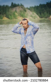 A Man With Dark Long Hair Emerges From The Water In A Wet Shirt