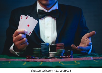 Man dealer or croupier shuffles poker cards show cards in a casino. Asain man holding two playing cards. Casino, poker, poker game concept - Shutterstock ID 2142428035