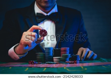 Man dealer or croupier shuffles poker cards show chip in a casino. Asain man holding two playing cards. Casino, poker, poker game concept