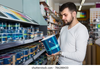 Man Is Deciding On Best Wall Paint In Paint Supplies Store. 