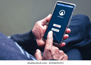 Man decision making moment on blocking unknown caller phone number to prevent voice phishing scam call. Selective focus.