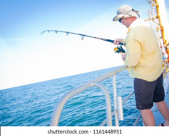 Man Deep Sea Fishing Reeling In A Fish.