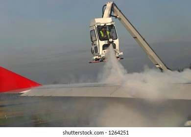 Man de-icing the airplaneâ€™s wing