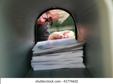 A man delivering or receiving mail in a mailbox