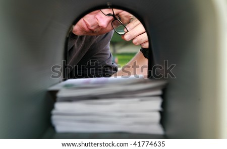 A man delivering or recieving mail in a mailbox