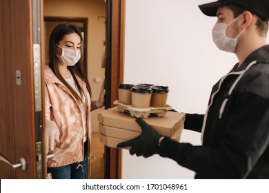 Man Delivery Pizza And Coffe To Customer In Mask And Gloves. Woman Open Door And Take Order. Coronavirus Theme