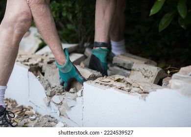 A Man Demolishing A Wall