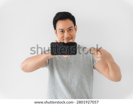 Man demonstrating app feature on smartphone, guiding through interface with pointing gestures, instructional tone for tutorial