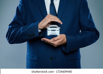 Man Demonstrating Image Of Auto On Grey Background, Closeup. Car Insurance