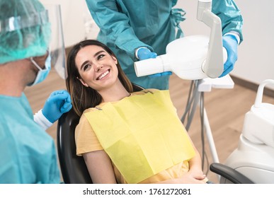 Man dentist operating young smiling woman in dental clinic - Oral healthcare assistance concept