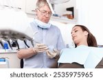 Man, dentist and woman with mould at clinic for cleaning treatment, veneers assessment and teeth whitening. Mature, orthodontics and patient with dental process, root canal and structure inspection