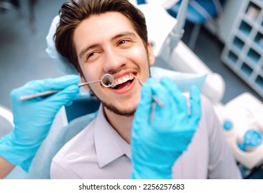 Man at the dentist's chair during a dental procedure. Overview of dental caries prevention.  Healthy teeth and medicine concept.  - Powered by Shutterstock