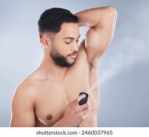 Man, deodorant and spray in studio for hygiene, fragrance and stop sweat for fresh scent by background. Model, person and liquid with perfume, aroma and clean armpit with healthy grooming routine