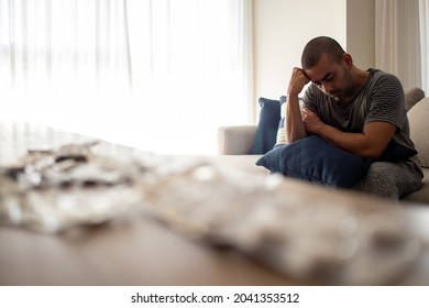 man in depression sitting on sofa with blue pillow