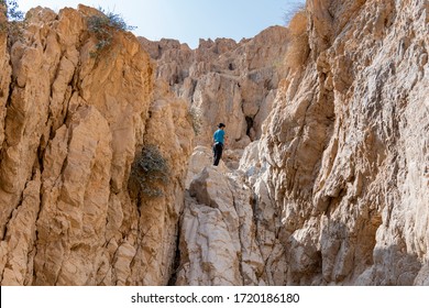 A man descends a high cliff in the desert, using rappelling. Abseiling Down Cliff. Cliff Rappel. - Powered by Shutterstock