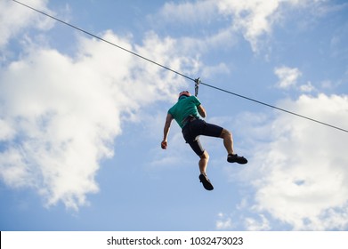 a man descends on a rope, a sport in an extreme park, A man walking along a zip line, - Shutterstock ID 1032473023