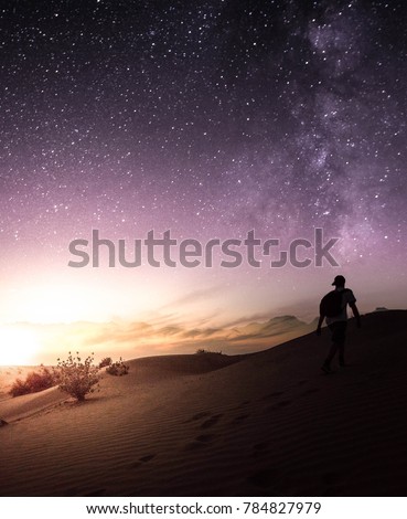 Man in desert with night sky during sunset, Dubai