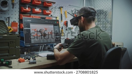 Man Designing and Assembling Drones. Engineer Wearing FPV Goggles Simultaneously Designing Drone on Screen and Assembling Workbench. Concept of Advanced Research and Development in Drone Technology.