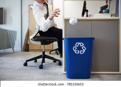 Man At Desk Throwing Screwed Up Paper Into Recycling Bin