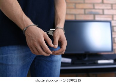 Man detained in handcuffs indoors, space for text. Criminal law - Shutterstock ID 1483992215