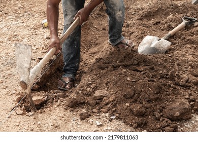 Man Digging In The Ground With A Shovel