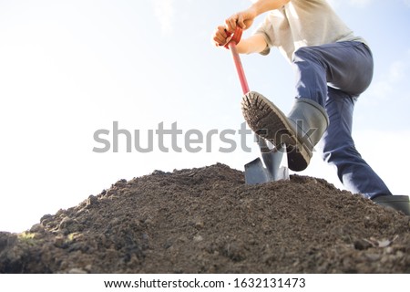 man digging the ground with shovel