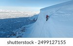 Man digging snow with shovel on glacier in Antarctica. Winter wild nature aerial panorama. People enjoy sunny day on Antarctic iceberg slope hill. Discover South Pole, travel, expedition, exploration.