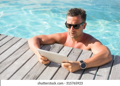 Man with digital tablet computer by the pool - Powered by Shutterstock