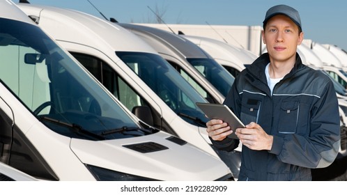 Man With A Digital Tablet On The Background Of Trucks. Fleet Management