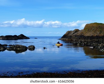 Man In Dinghy Rowing In A Rocky Bay, Ballintoy, Northern Ireland