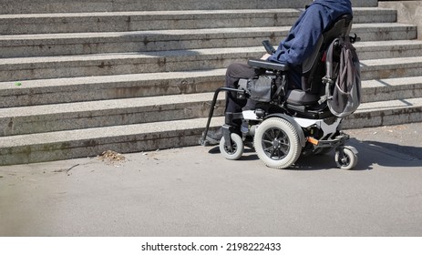 Man With Disability On Wheelchair Stopped In Front Of Staircase, Raising Awareness Of Architectural Barriers And Accessibility Issues