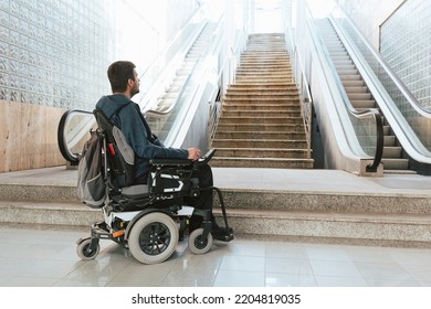 Man with disability on wheelchair stopped in front of staircase, raising awareness of architectural barriers and accessibility issues - Shutterstock ID 2204819035