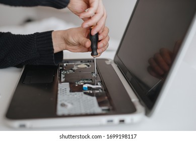 A man disassembles a laptop. Computer service and repair concept. Laptop disassembling in repair shop, close-up. Electronic development, electronic device fixing - Shutterstock ID 1699198117