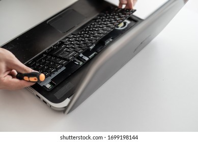 A man disassembles a laptop. Removes the keyboard. Computer service and repair concept. Laptop disassembling in repair shop, close-up. Electronic development, technology fixing - Shutterstock ID 1699198144